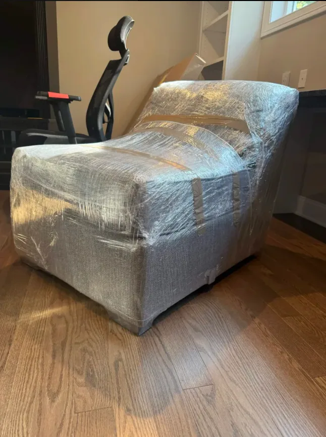 Lounge chair thoroughly wrapped in protective plastic before moving